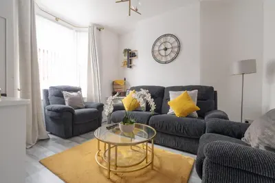 a living room with two couches and a glass table at Newly Renovated 4BR House with lots of amenities in Liverpool