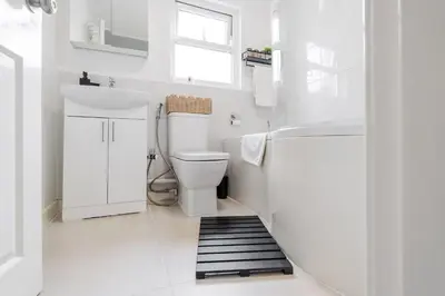 a white bathroom with a toilet and a sink at Newly Renovated 4BR House with lots of amenities in Liverpool