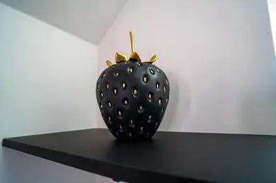 a black strawberry sitting on top of a black table at The Scouse Suite in Liverpool