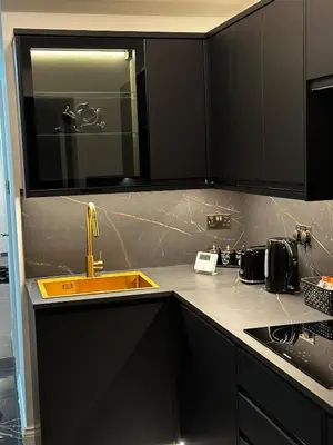 a kitchen with black cabinets and a yellow sink at The Scouse Suite in Liverpool