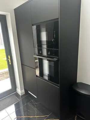 a black cabinet with a microwave oven in it at The Scouse Suite in Liverpool