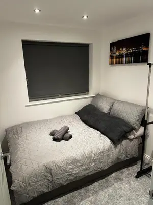a bedroom with a bed with a flat screen tv at The Scouse Suite in Liverpool