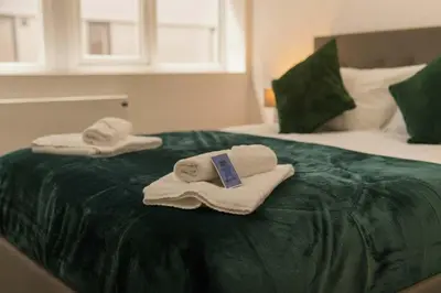 two towels sitting on top of a bed at Cosy & Bright 1 Bedroom Preston Apartment in Preston