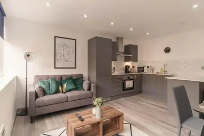 a living room with a couch and a kitchen at Cosy & Bright 1 Bedroom Preston Apartment in Preston