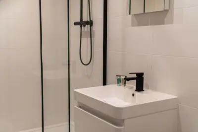 a white bathroom with a sink and a shower at Cosy & Bright 1 Bedroom Preston Apartment in Preston