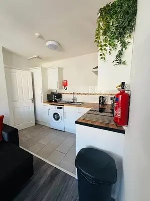 a kitchen with a red fire extinguisher on a counter at JMC Place - The Duplex in Blackpool
