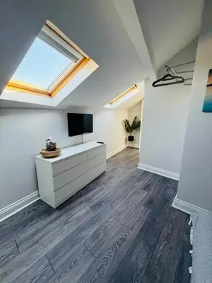 a living room with a television and a white cabinet at JMC Place - The Duplex in Blackpool