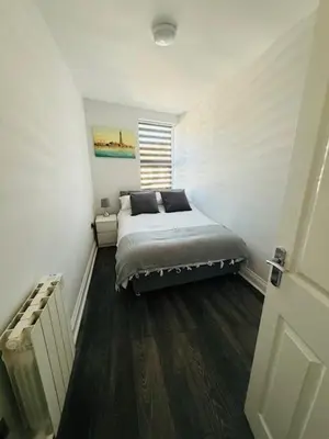 a bedroom with a bed in the corner of a room at JMC Place - The Duplex in Blackpool