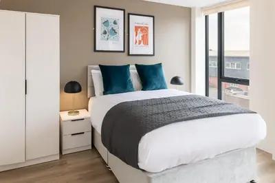 a bedroom with a large bed with blue pillows at Contemporary 1BED Apartment in Central Liverpool in Liverpool