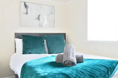a bedroom with a bed with a blue blanket at Sleek and Stylish 3 Bed in Bolton-Garden-Parking in Bradshaw