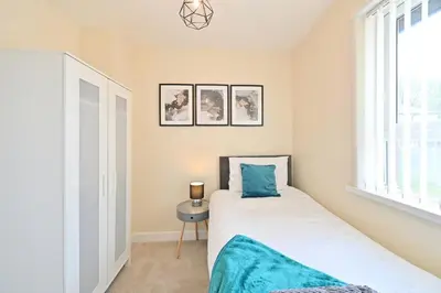 a bedroom with a bed and a window at Sleek and Stylish 3 Bed in Bolton-Garden-Parking in Bradshaw