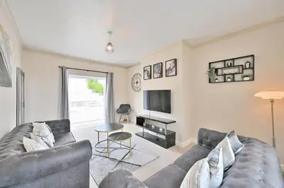 a living room with a couch and a tv at Sleek and Stylish 3 Bed in Bolton-Garden-Parking in Bradshaw