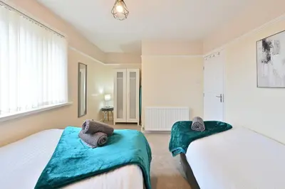 a bedroom with two beds with blue cushions at Sleek and Stylish 3 Bed in Bolton-Garden-Parking in Bradshaw