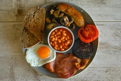 a plate of breakfast food with eggs beans and toast at Staining Luxury Lodges in Poulton le Fylde