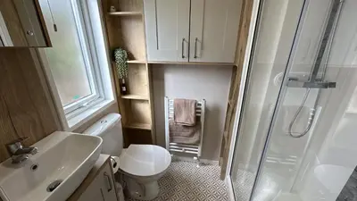 a small bathroom with a toilet and a shower at Hobbit - House Of The Owl - Luxury Lodge with Pool in Longridge