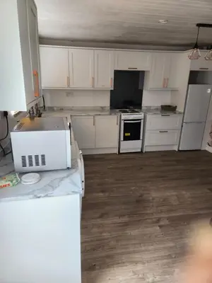 a kitchen with white cabinets and a counter top at Okwute,s House in Skelmersdale