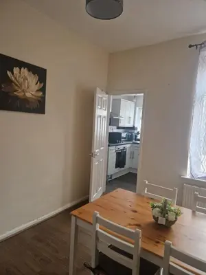 a dining room with a table and a kitchen at Leyland Town Centre Quiet Hub 2 bedroom 4 beds superfast WIFI free parking close to station and High Street in Leyland