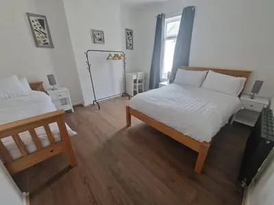 a bedroom with two beds and a window at Leyland Town Centre Quiet Hub 2 bedroom 4 beds superfast WIFI free parking close to station and High Street in Leyland
