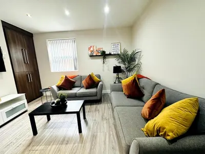 a living room with a couch and a table at Lovat House - Large 6-Bedroom Property in Preston