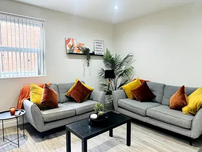 a living room with two couches and a table at Lovat House - Large 6-Bedroom Property in Preston