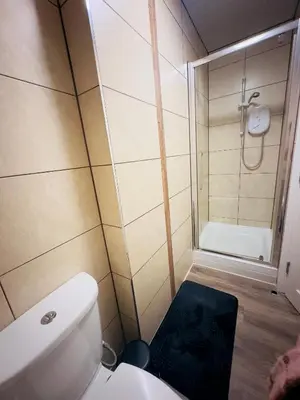 a small bathroom with a toilet and a shower at Lovat House - Large 6-Bedroom Property in Preston