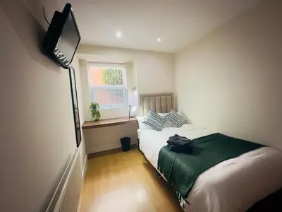 a small bedroom with a bed and a window at Lovat House - Large 6-Bedroom Property in Preston