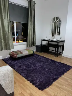 a living room with a purple rug and a desk at KD Homes in Horwich