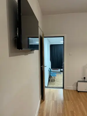 a room with a door leading to a room with a blue chair at KD Homes in Horwich