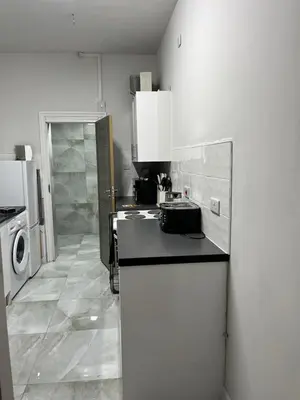 a kitchen with a sink and a refrigerator at KD Homes in Horwich