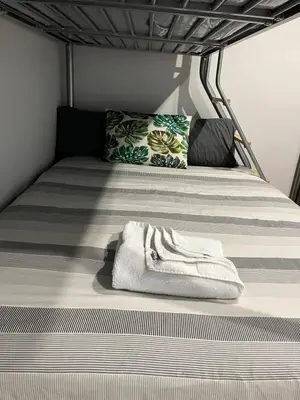 a bed with a white towel sitting on top of it at KD Homes in Horwich