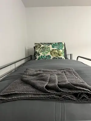 a blanket laying on a bed with a pillow at KD Homes in Horwich