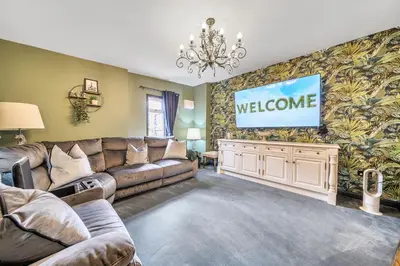 a living room with a couch and a flat screen tv at The Stables in Poulton le Fylde