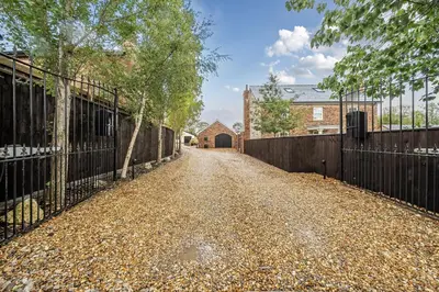 an empty driveway with a gate and a house at The Stables in Poulton le Fylde