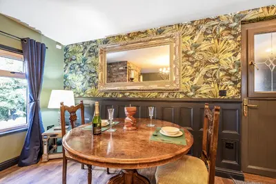 a dining room with a table and a mirror at The Stables in Poulton le Fylde