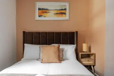 a bed with white pillows and a picture on the wall at City Centre Retreat 2BR 2BA Parking Included in Liverpool