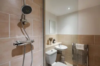 a bathroom with a shower and a toilet and a sink at City Centre Retreat 2BR 2BA Parking Included in Liverpool