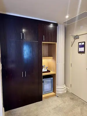 a large wooden cabinet with a microwave in a room at Fenwick Street Hotel by EPIC in Liverpool