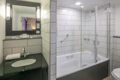 a bathroom with a shower and a sink and a tub at Fenwick Street Hotel by EPIC in Liverpool