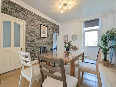 a dining room with a wooden table and chairs at Bright 4BR Home Near Anfield & Free Parking in Liverpool