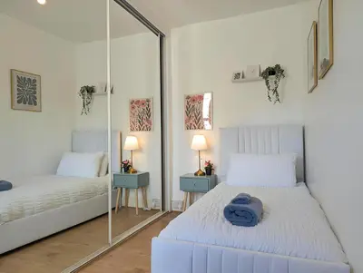 a bedroom with two beds and a mirror at Bright 4BR Home Near Anfield & Free Parking in Liverpool