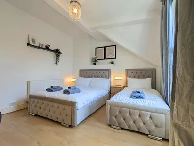 two beds sitting in a room with two lamps at Bright 4BR Home Near Anfield & Free Parking in Liverpool