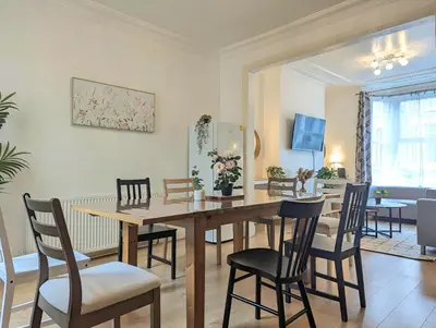 a dining room with a wooden table and chairs at Bright 4BR Home Near Anfield & Free Parking in Liverpool