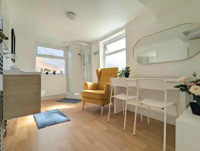 a living room with a dining room table and a chair at Bright 4BR Home Near Anfield & Free Parking in Liverpool