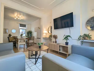 a living room with a couch and a table at Bright 4BR Home Near Anfield & Free Parking in Liverpool
