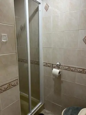 a shower with a glass door in a bathroom at Cadeby Lodge in Blackpool