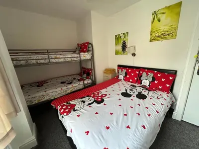 a bedroom with a bed with hello kitty pillows at Cadeby Lodge in Blackpool
