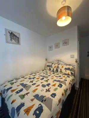a bedroom with a bed with a comforter on it at Cadeby Lodge in Blackpool