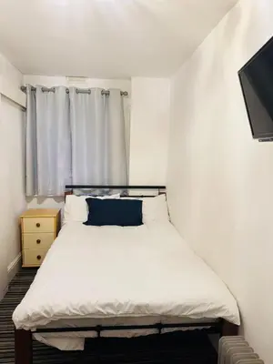 a small bedroom with a bed and a window at Cadeby Lodge in Blackpool