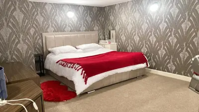 a bedroom with a large bed with a red blanket at Chic & Central Liverpool Flat in Liverpool