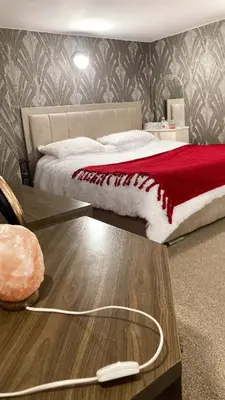 a bedroom with a bed with a red blanket and a table at Chic & Central Liverpool Flat in Liverpool
